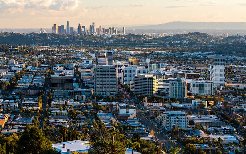Downtown Glendale at sunset with downtown Los Angeles skyline and mountains in the background.